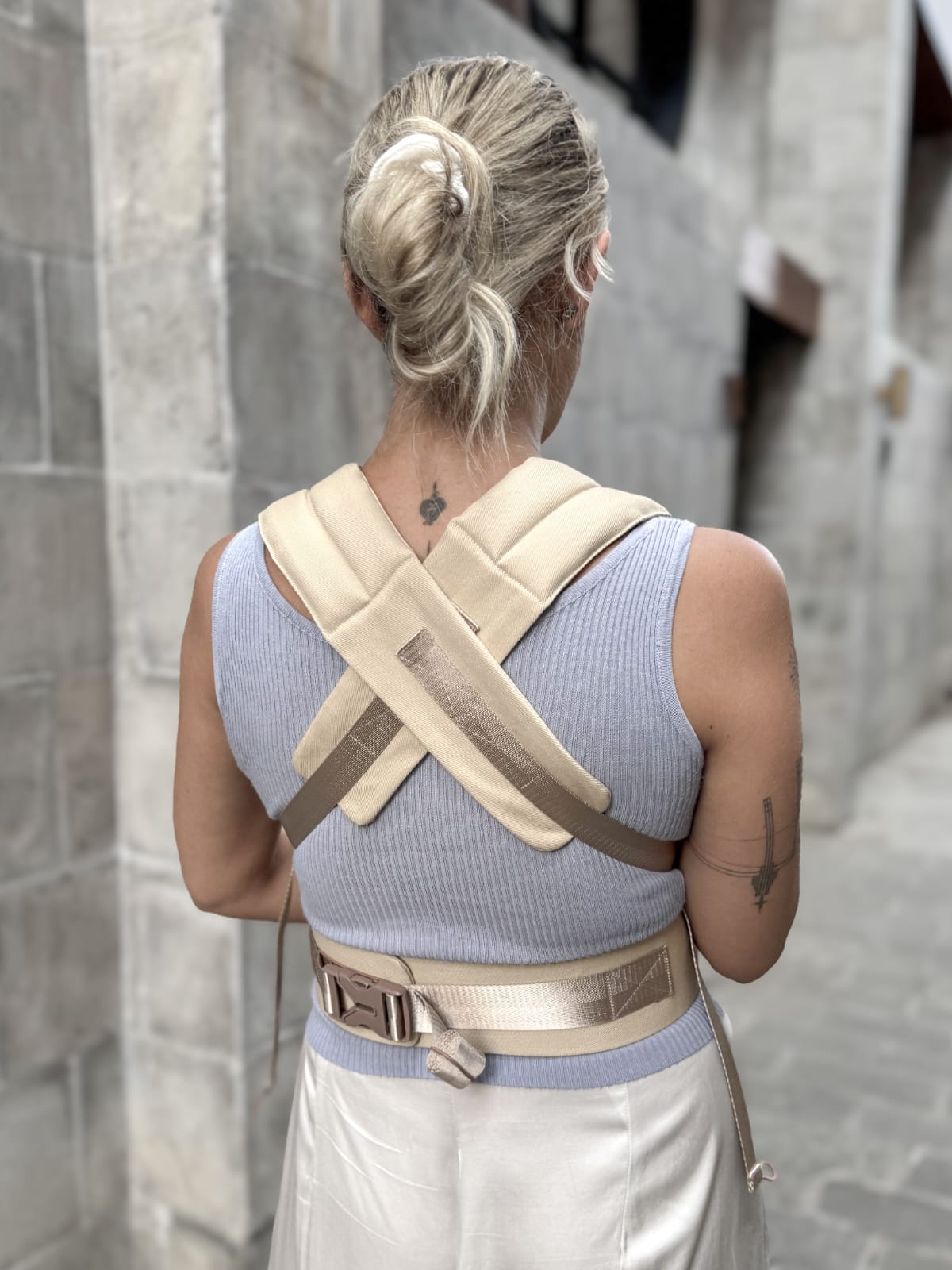 woman wearing sand color baby carrier with supportive belt