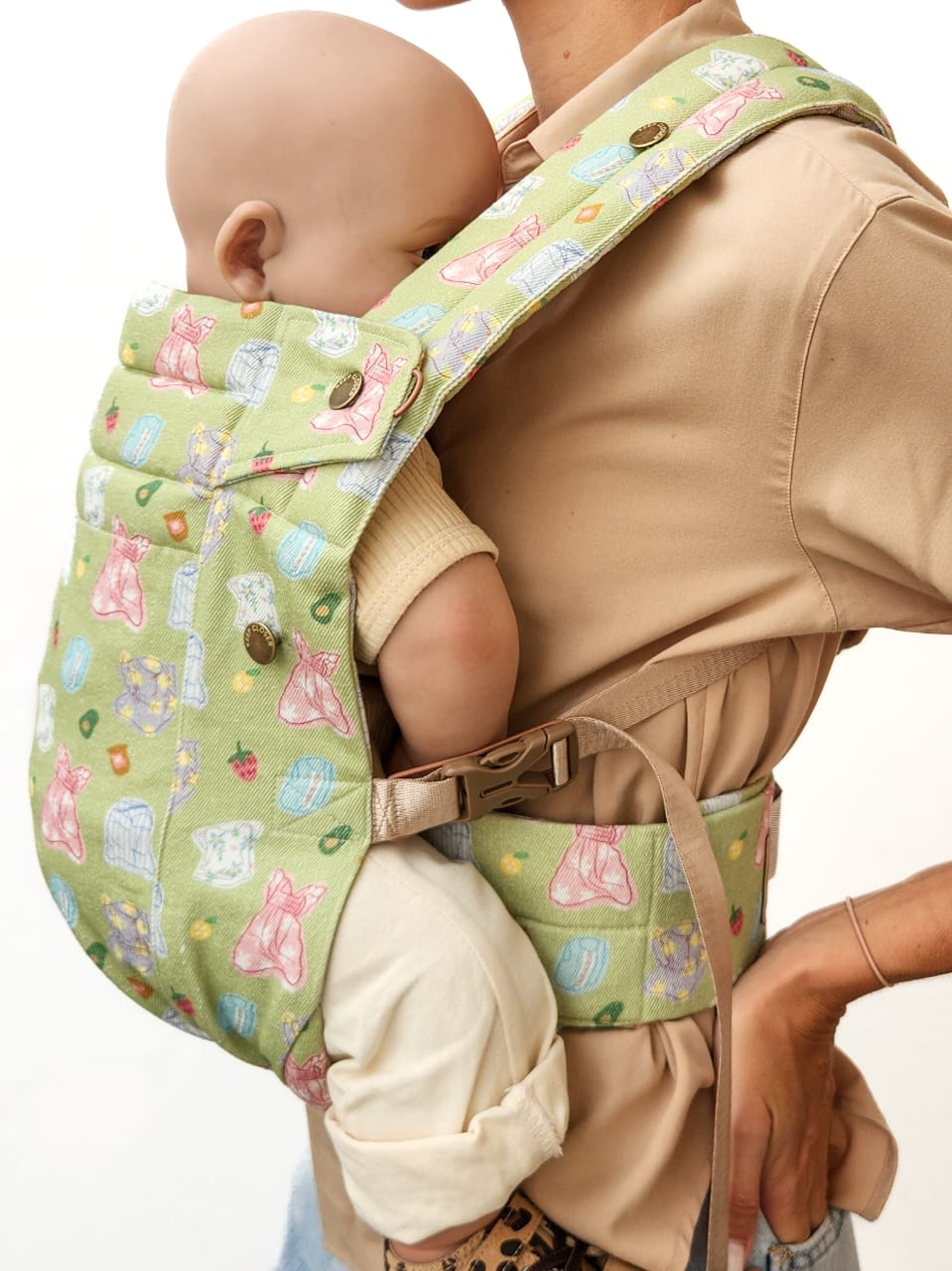 Baby carrier with a pattern of dresses on a plain background