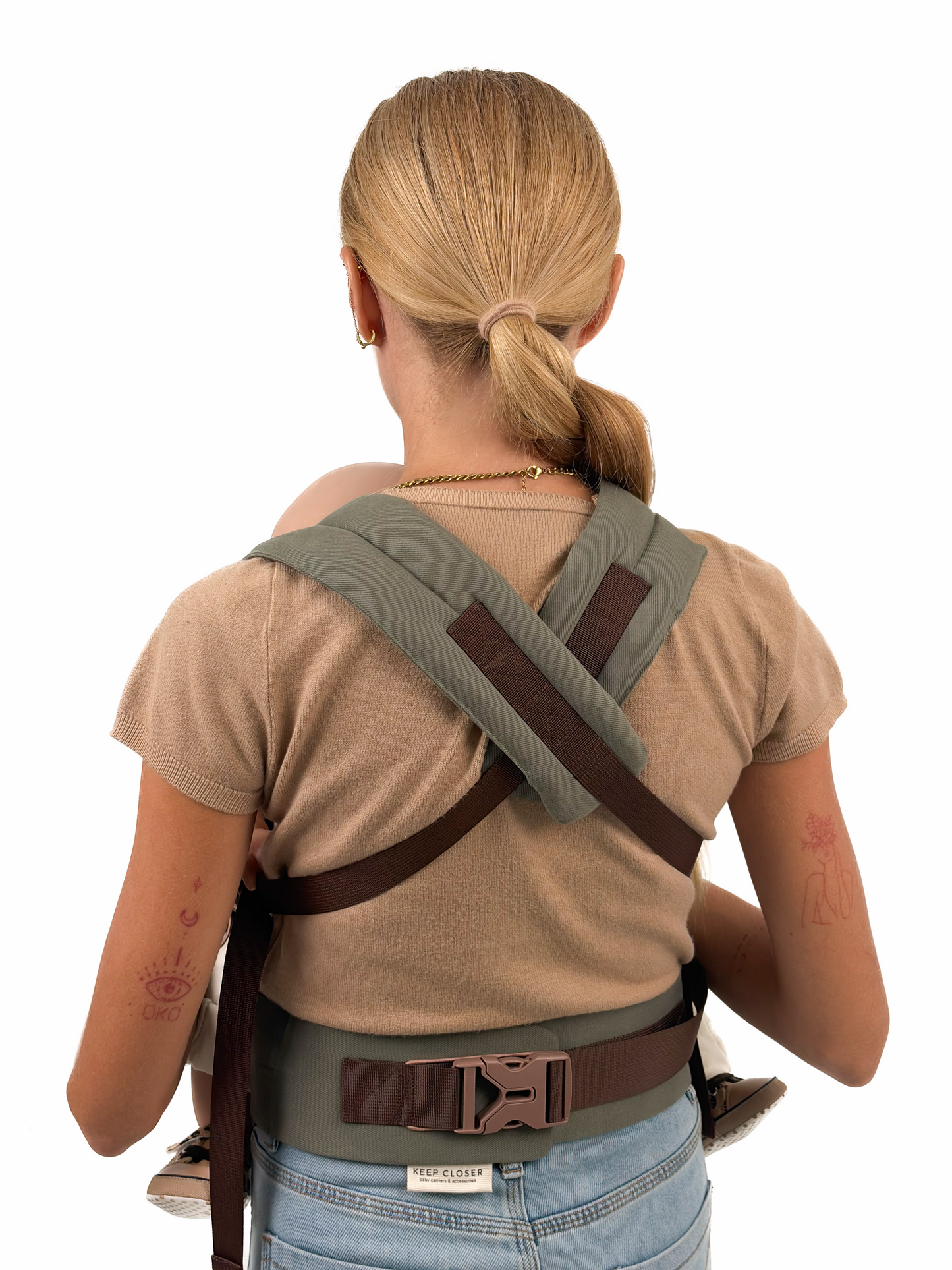 Back view of Khaki Comfort Fit Ergonomic Baby Carrier worn by mother, showing olive khaki cross-back shoulder straps and dark brown waistband with buckle, white background
