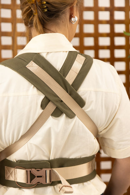Person wearing a green and beige back brace against a wooden lattice background