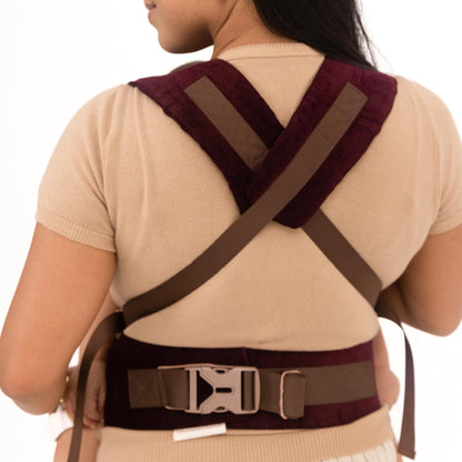 Woman wearing a limited edition maroon baby carrier, back support belt on a white background